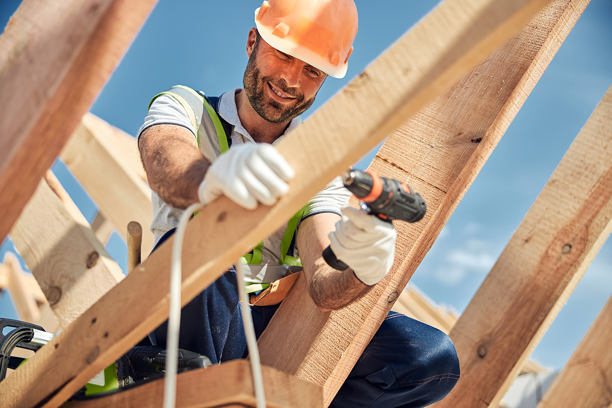 Cheerful constructor keeping smile on his face while doing his job with great pleasure