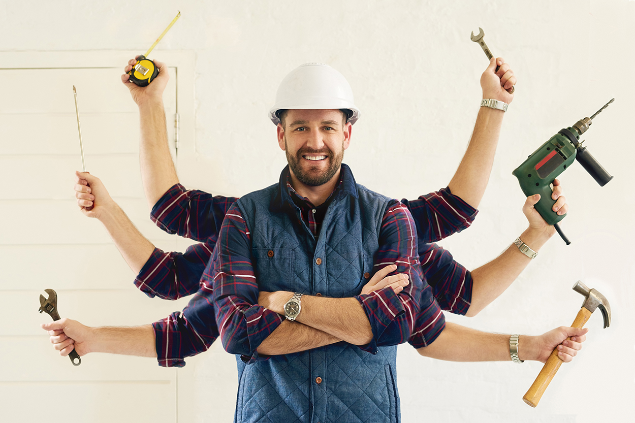 Portrait of a handsome young handyman tools in multiple hands.